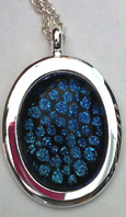 Click for a larger photo of the Clear Glass on Bluish Green Reptile Patterned Oval in Silver-plated Setting